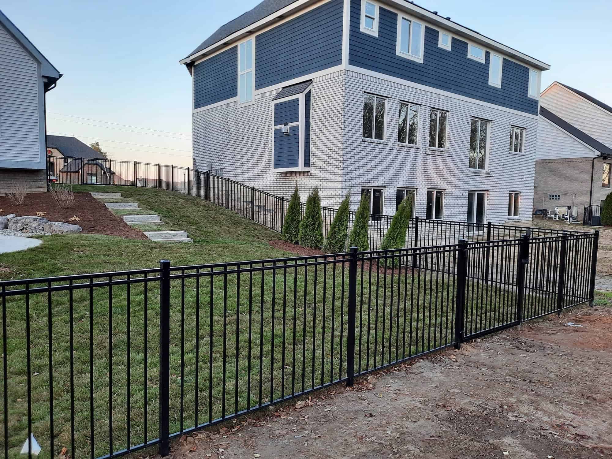 Modern house with black metal fence and lawn