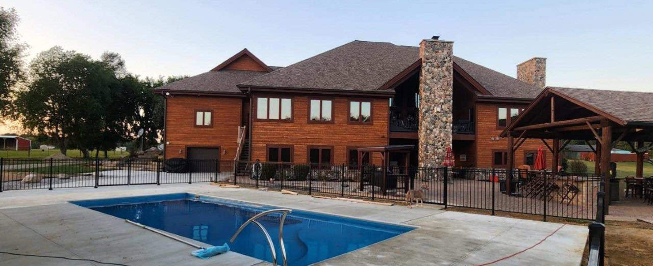 Spacious wooden house with backyard pool and patio.