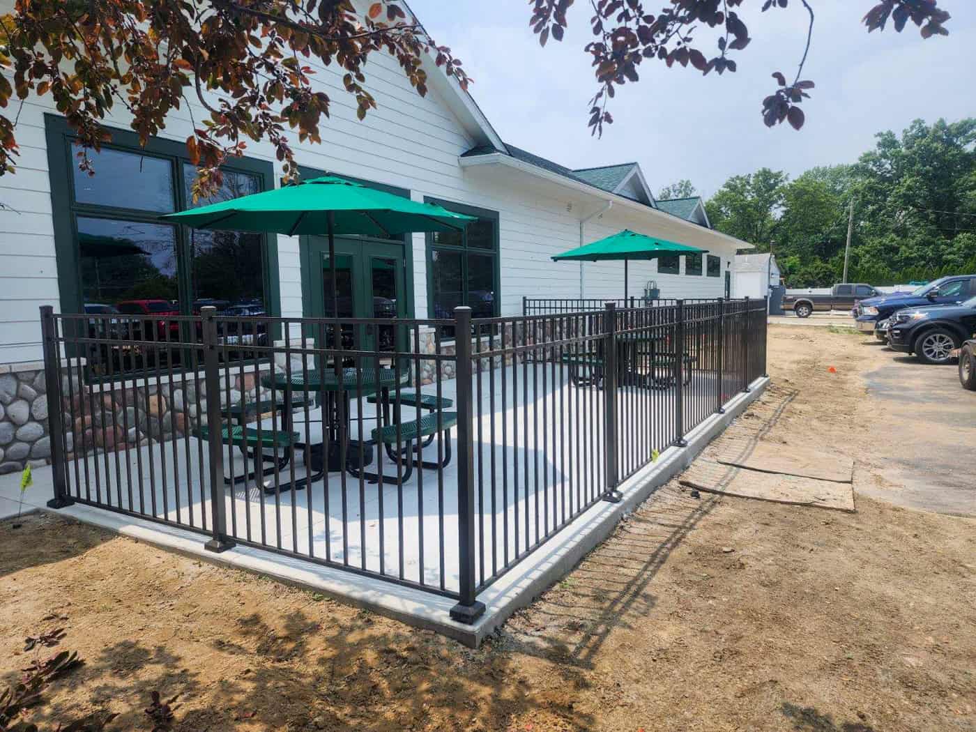 Outdoor patio with green umbrellas and tables.