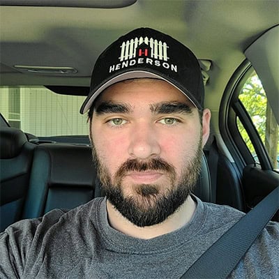 Person in car wearing Henderson cap.