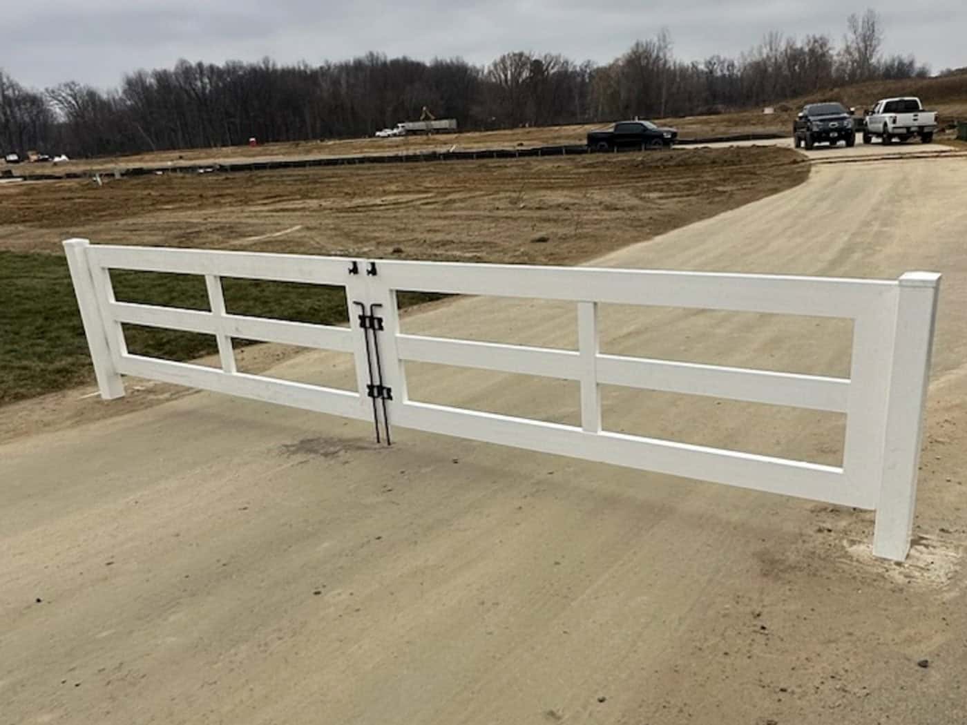 White gate on dirt road in rural area.